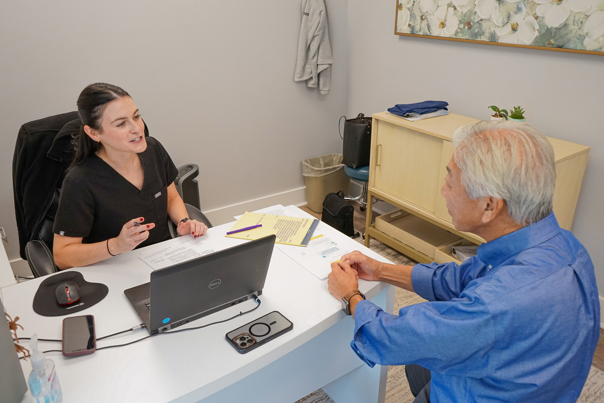 provider at sitting at desk talking to Dr. Chin